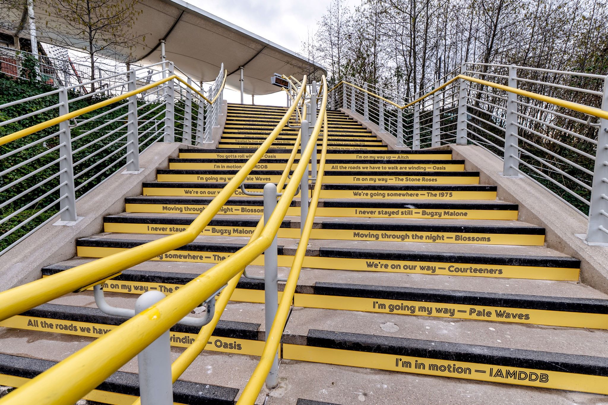 Etihad Campus tram stop stair graphics with Manchester music lyrics