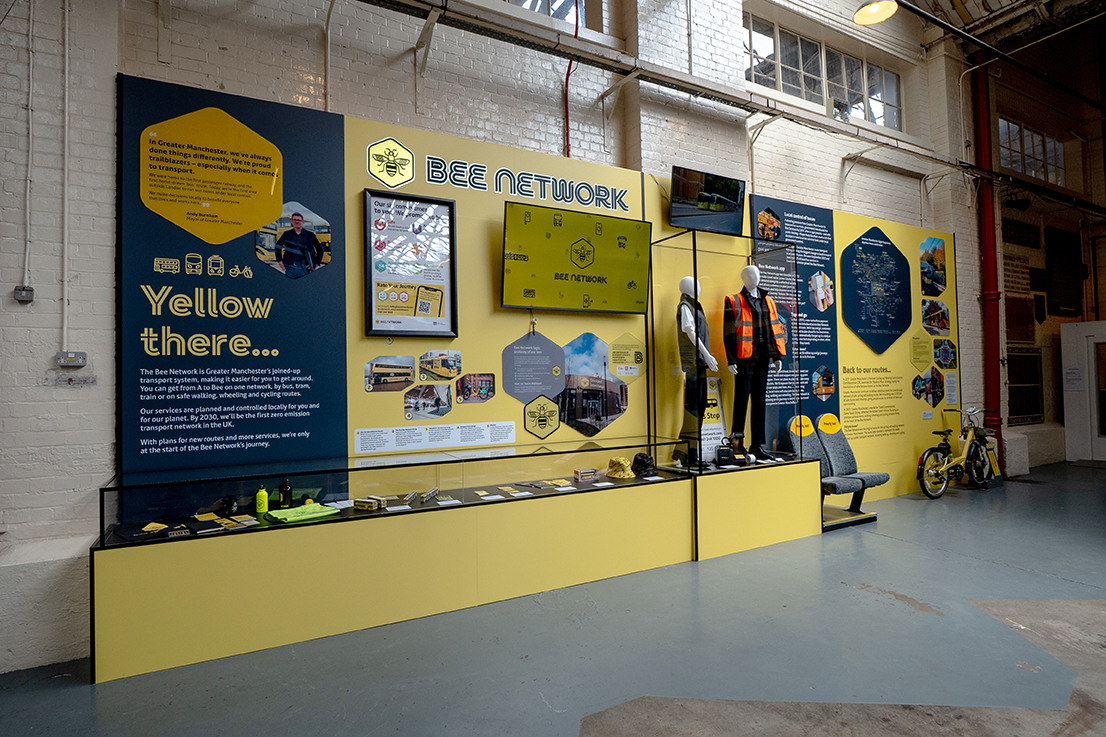 Bespoke museum exhibition display featuring MDF backboards, acrylic display cases, illuminated lettering and branded Bee Network graphics.